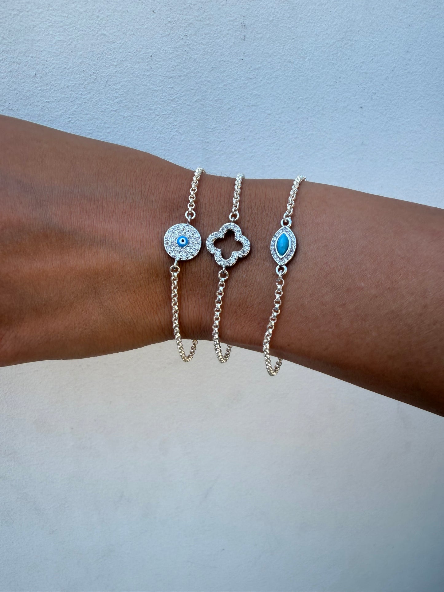 Sterling silver rolo link chain link bracelet with evil eye or clover connector