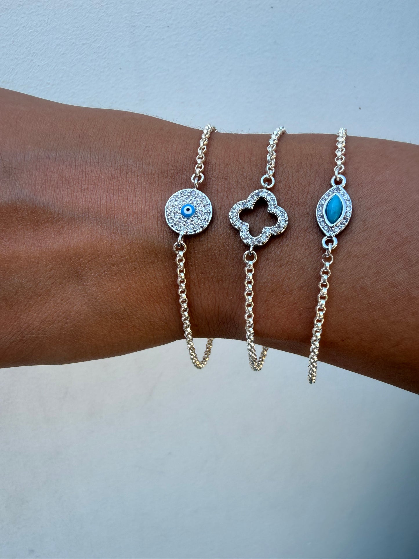 Sterling silver rolo link chain link bracelet with evil eye or clover connector