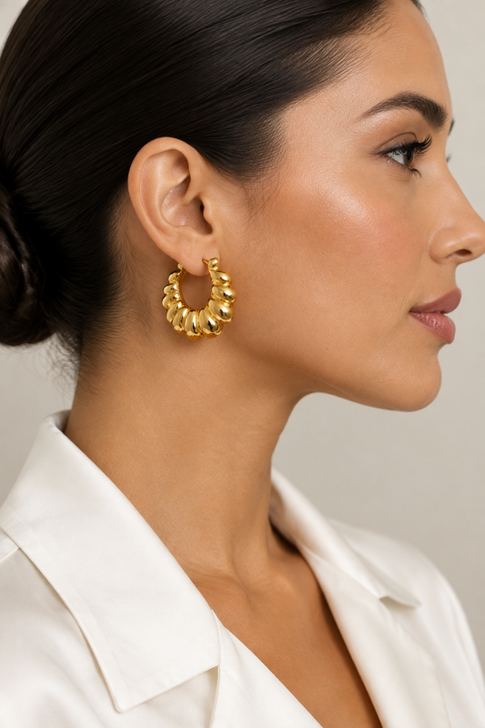 Side profile of a Latina model in a white blouse wearing the gold croissant hoops